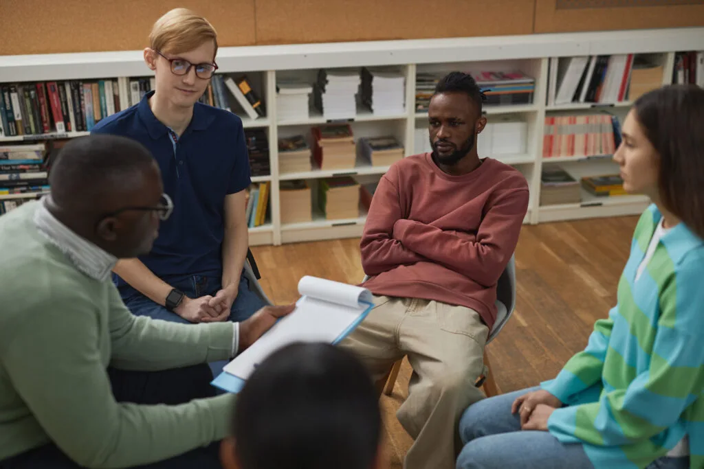 Group of young people sitting in circle during the