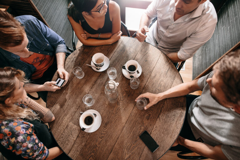Group of people having coffee to connect about recovery