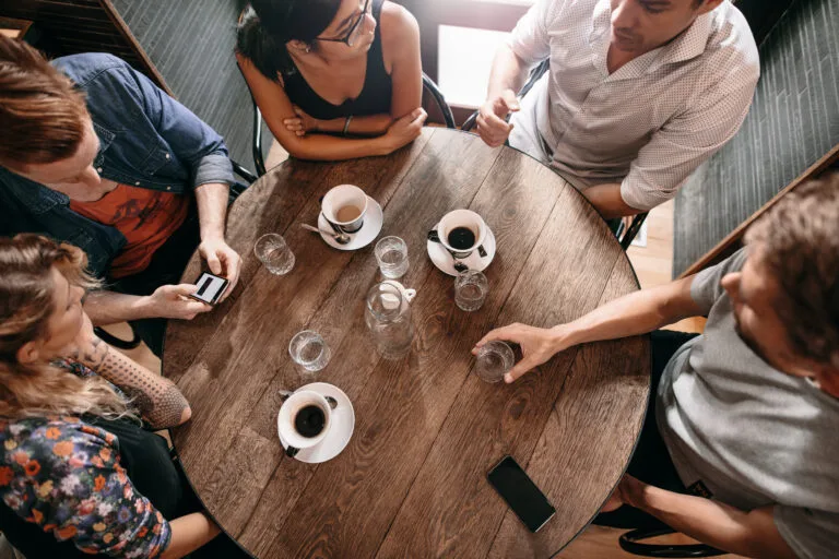 Group of people having coffee to connect about recovery