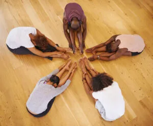 group doing yoga stretching together